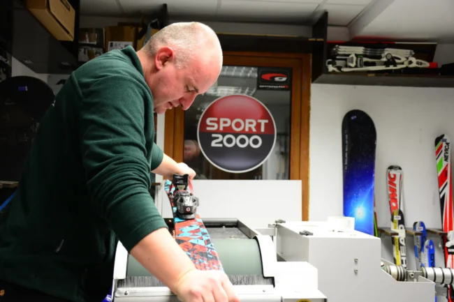 Technician tuning skis at Ski and Board Traventuria service center in Bansko