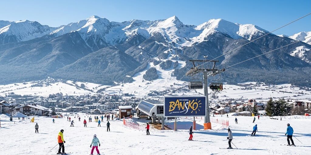 bansko-winter-resort-logo-mountain Overview of skiers on snow slopes and lift at Bansko ski resort